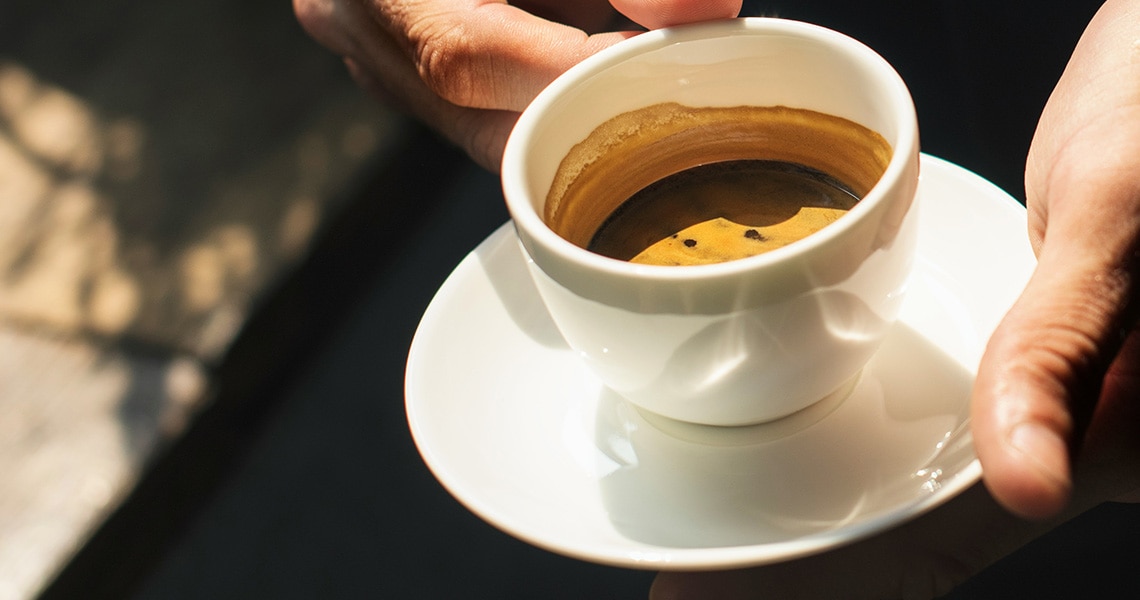 Persona con una taza de café espresso en la mano